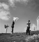 Deux techniciens surveillent le yacht qui s'éloigne au large dans "La Fleur de l'âge" de M. Carné et J. Prévert, Belle-Ile, 1947