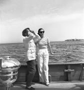 Marcel Carné scrute le ciel en compagnie d'Arletty  (Florence) sur le yacht "Le Valrosa" dans "La Fleur de l'âge" de M. Carné et J. Prévert, Belle-Ile, 1947